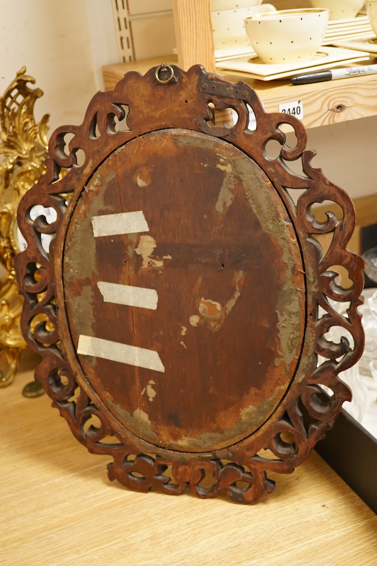 An oval carved wood mirror, 53cm high